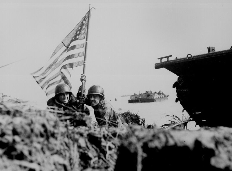 Soldiers hoisting flag guam beach